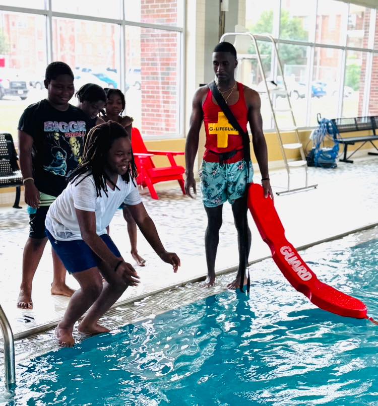 A boy jumping into a swimming pool.